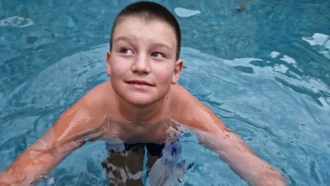 Child having blast on vacation in pool Shimmering water of the pool provides Stock Footage 265990339