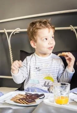 Child having breakfast in bed Stock Photos