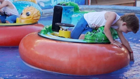 Child having fun on the electric boat. Water attractions Stock Footage 113458804
