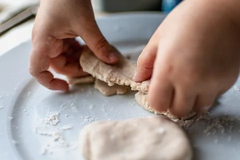 Child having fun modeling salt dough, authentic activity, fine motor skills.. Stockfoto's