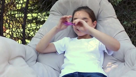 Child having fun outdoors with Spinner. Young caucasian girl showing skills by f Video stock 76878308