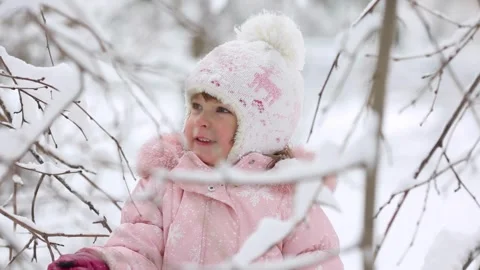 A child is having fun outdoors in winter forest. A little girl plays in a n.. Stock Footage 345936801