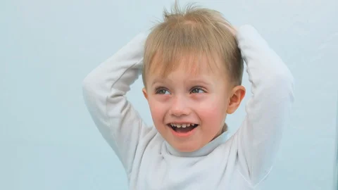 The child is having fun, smiling and doing a hairstyle Stock Footage 128841783
