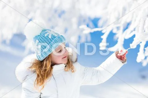 Child having fun in snowy winter park Stock Photos