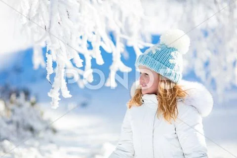 Child having fun in snowy winter park Stock Photos