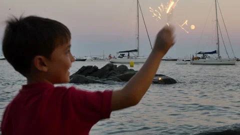 Child having fun with a sparkling flare at sunset Stock Footage 95595443