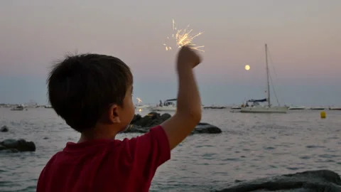 Child having fun with a sparkling flare at sunset Stock Footage 95595553
