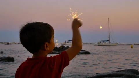 Child having fun with a sparkling flare at sunset Stock Footage 95595557