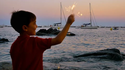 Child having fun with a sparkling flare at sunset Stock Footage 95595974