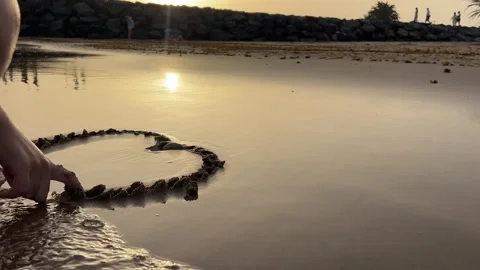 A Child Having Fun While Playing by the Shore, Creating Beautiful Patterns in Stock Footage 317073197