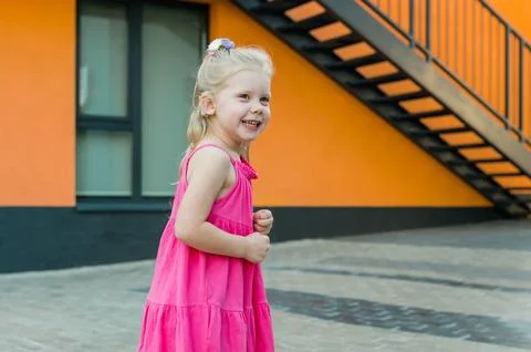 Child with hearing problem and cochlear implant plays in street, deaf kid began Stock Photos