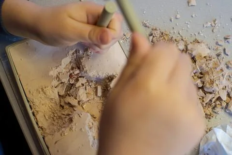 A child with the help of a geologist's kit extracts a jasper in a plaster cas Foto stock