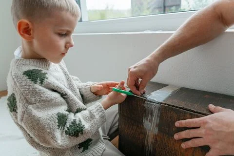 Child Helping Open Box Stock Photos