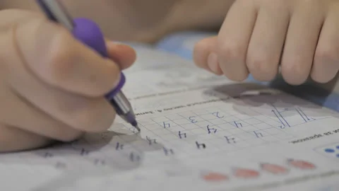 Child hesitantly writes in workbook. Stock Footage 122755350