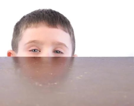 Child hiding behind kitchen table Photos