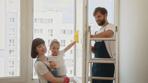 A child with his parents washes the windows. Kids clean the house. Children help Stock Footage 232033717