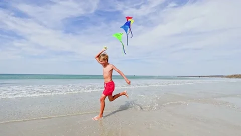 Child hold parachute fly on wind at ocean beach profile image 스톡 동영상 228781780