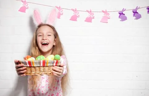 Child is holding a basket with Easter eggs Stock Photos