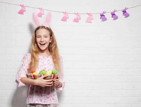Child is holding a basket with Easter eggs Stock Photos
