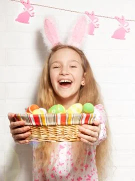 Child is holding a basket with Easter eggs Stock Photos