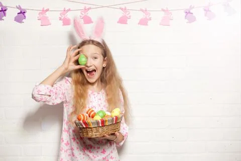 Child is holding a basket with Easter eggs Stock Photos