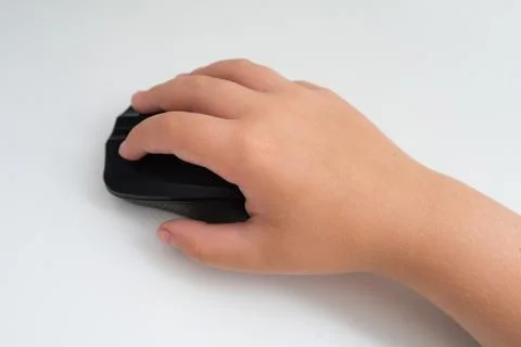 A child is holding a computer mouse with its hand on a white background Stock Photos