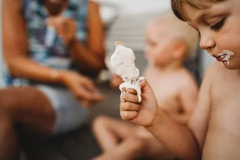 Child holding cream ice cream melting down his hands getting dirty Stock Photos
