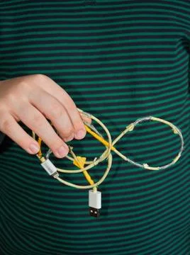 The child is holding an old torn USB cord in his hand. Stock Photos