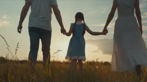 Child holding parent hands while walking sunset, children walk parents dawn, chi Stock Footage 334833960