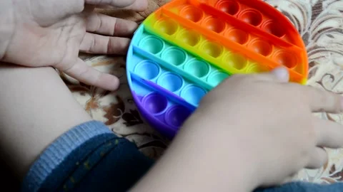 The child is holding POP IT in his hand, taking a break from modern gadgets. Stock Footage 155297815