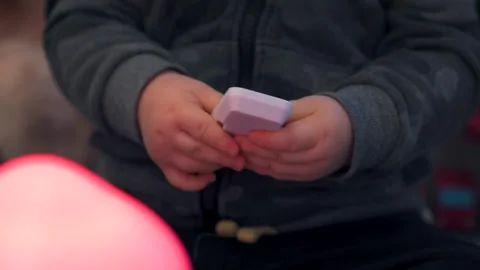 Child Holding Small White Remote Control: Close-Up Video stock 325131419