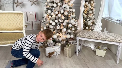 A child holds a box in a festive package. The boy is happy about the holiday Stock Footage 220710830