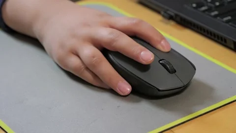Child holds the computer mouse,child learns and plays on the computer Stock-Footage 266494666