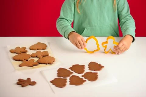 The child holds cookie forms in the shape of a man and a Christmas tree for m Foto stock