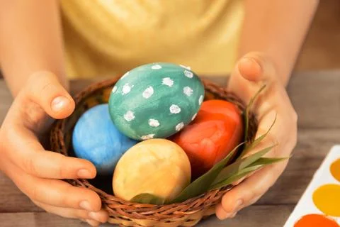 Child holds Easter basket with eggs Stock Photos
