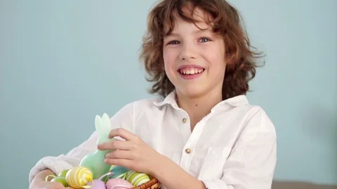A child holds a Easter bunny and a set of decorative Easter eggs. The boy laughs Stock Footage 87505539