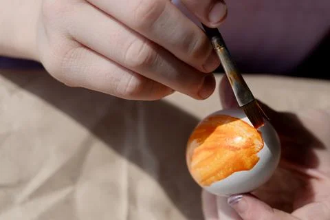 The child holds an Easter egg in his hands. Close-up Stock Photos