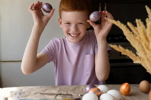 The child holds an Easter egg in his hands. Close-up Stock Photos
