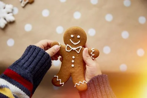 Child holds homemade gingerbread cookie on basic dots background. Festive Stock Photos