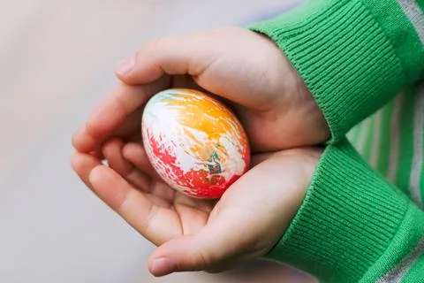 A child holds a painted Easter egg in his hands Stock Photos