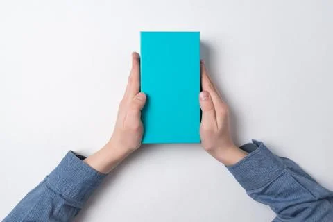 Child holds rectangular blue box on white background. Top view. Gift for chil Stock Photos
