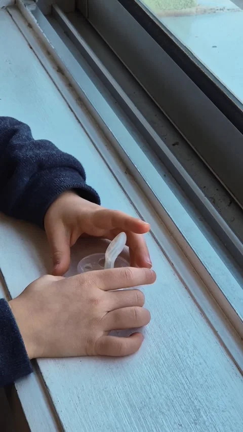 A child holds a worn-out pacifier with a torn nipple 库存影片 301329858