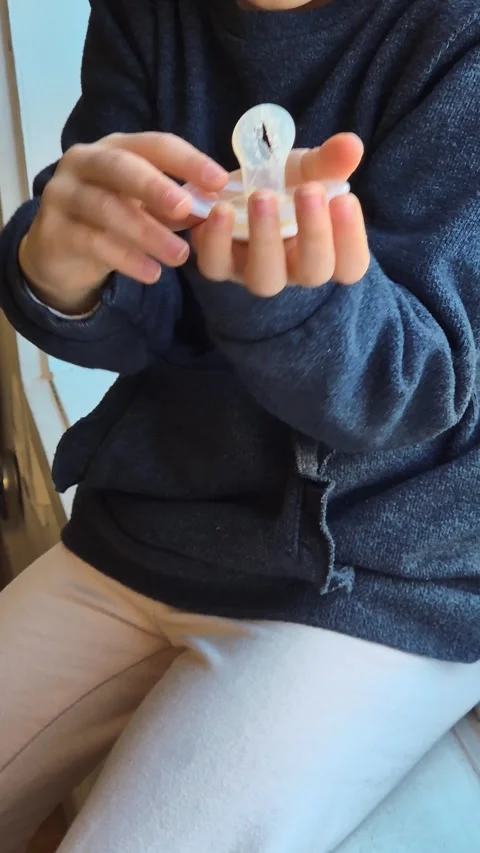 A child holds a worn-out pacifier with a torn nipple 库存影片 301329874
