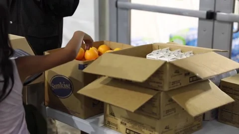 Child immigrant takes orange from box at temporary processing facility in Texas Видео 151251742