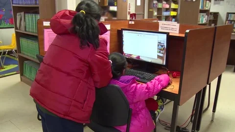 Child immigrants playing on computer at Texas residential immigration center Stock Footage 114555702