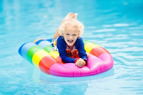 Child on inflatable float in swimming pool. Stock Photos