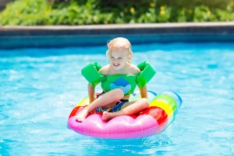 Child on inflatable float in swimming pool. 스톡 사진