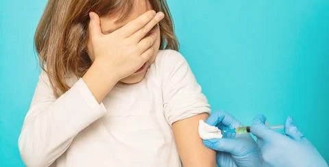 The child is injected into the arm. Selective focus. Stock Photos