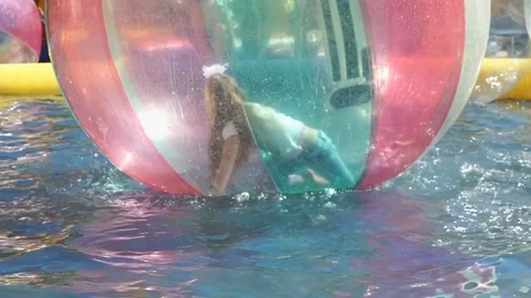 Child inside big inflatable ball on water surface Vídeo Stock 71660568