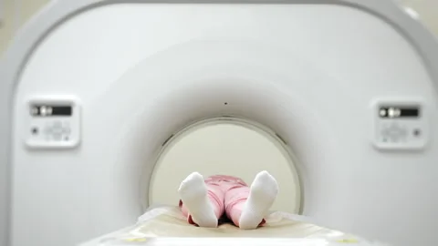 Child inside CT scanner during medical imaging procedure. 스톡 동영상 347776257